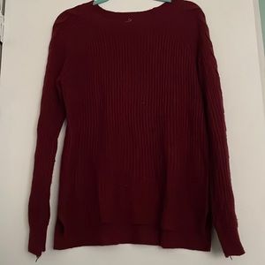 Maroon sweater with braided sleeves.
